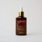 Brown serum bottle with gold cap and white dropper on a light gray background